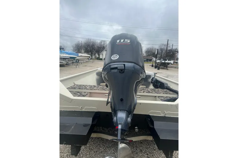 Slide: The Image of 2001 SeaArk 2272 MV boat with 115 HP outboard motor, parked on gravel. - 8