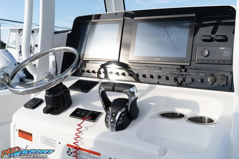 Slide: The Image of Control panel of 2026 Sea Hunt Ultra 265 SE boat with Garmin displays and steering wheel. - 26