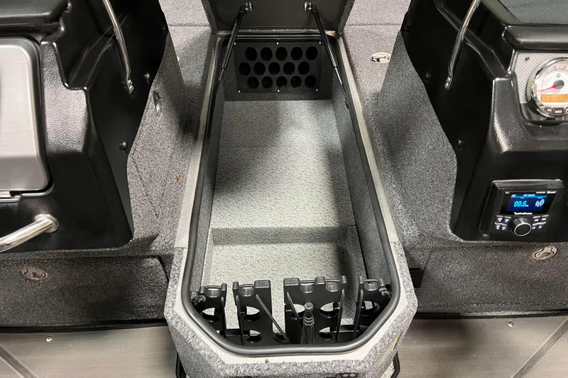 Slide: The Image of 2023 Lund 2175 Pro-V boat interior storage compartment with control panel and radio display. - 15