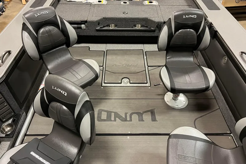 Slide: The Image of 2023 Lund 2175 Pro-V boat interior with four black and gray seats. - 25