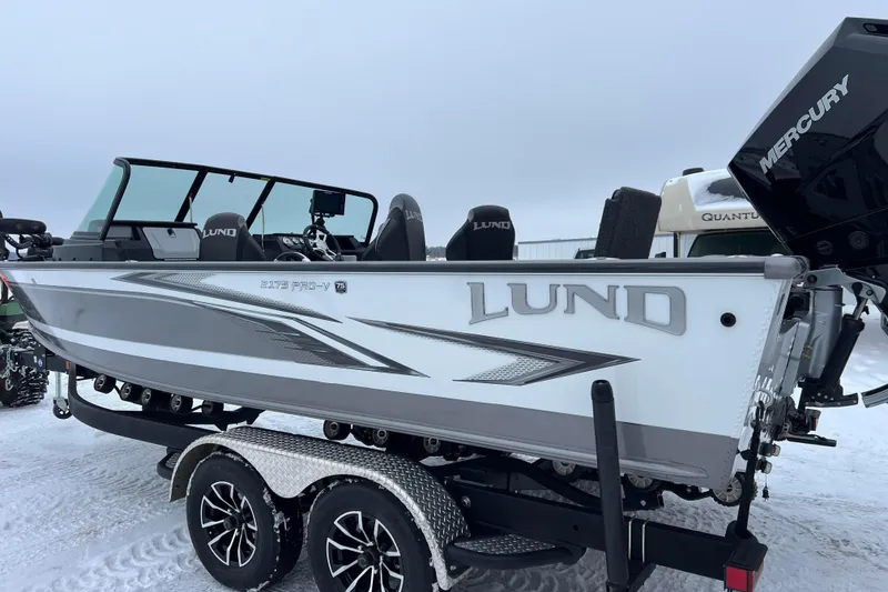 Slide: The Image of 2023 Lund 2175 Pro-V boat on trailer by serene lake at sunset. - 3