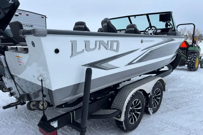 Slide: The Image of 2023 Lund 2175 Pro-V boat on trailer by lake at sunset. - 4