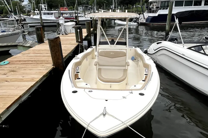 Slide: The Image of 2023 Scout 215 XSF boat docked at marina, showcasing sleek design and spacious seating. - 3