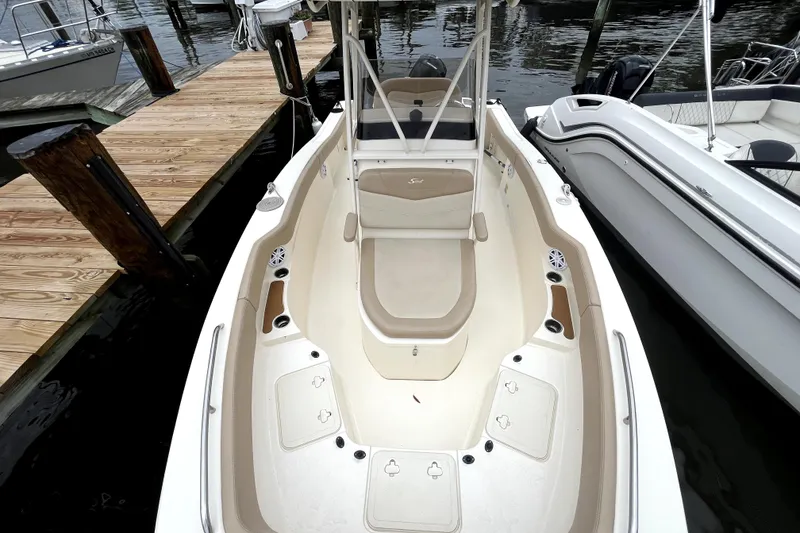 Slide: The Image of 2023 Scout 215 XSF boat docked, showcasing spacious seating and sleek design. - 4