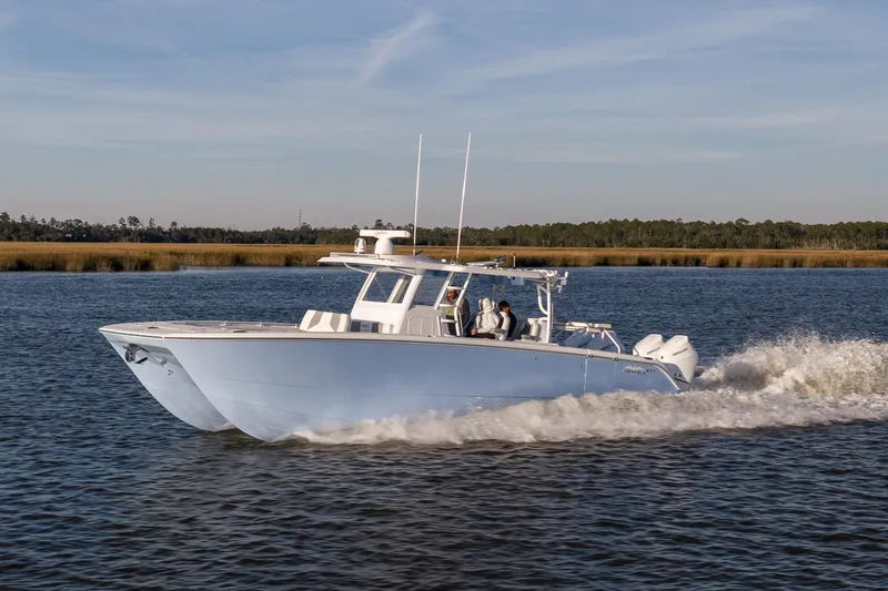 Slide: The Image of 2024 Invincible 40 Catamaran cruising on a serene waterway. - 11