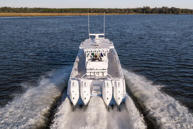 Slide: The Image of 2024 Invincible 40 Catamaran cruising on open water, rear view with powerful engines. - 13