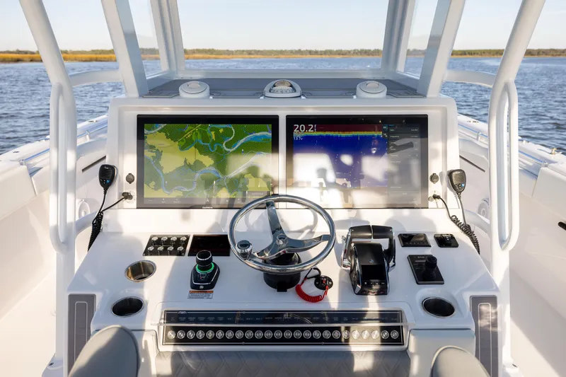 Slide: The Image of 2024 Invincible 40 Catamaran helm with dual navigation screens and steering wheel. - 33