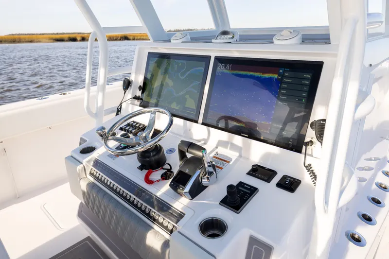 Slide: The Image of 2024 Invincible 40 Catamaran helm with dual navigation screens and steering wheel. - 35