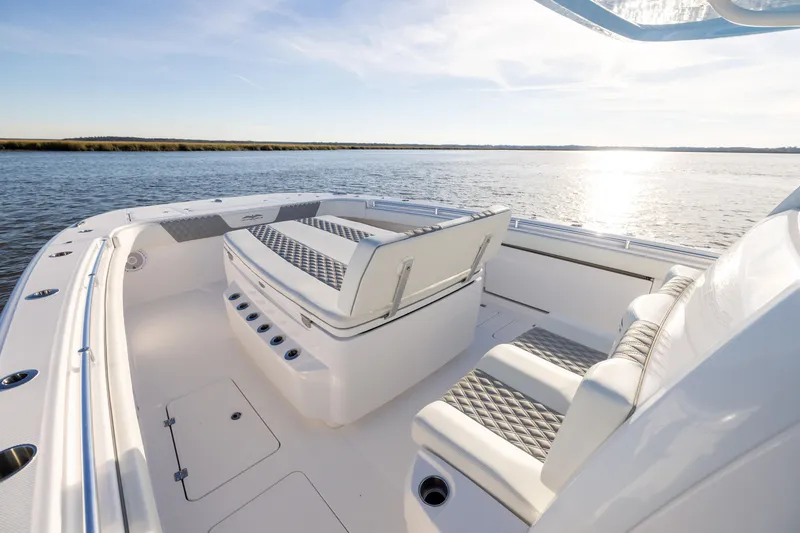 Slide: The Image of 2024 Invincible 40 Catamaran interior with luxurious seating, overlooking serene water. - 48