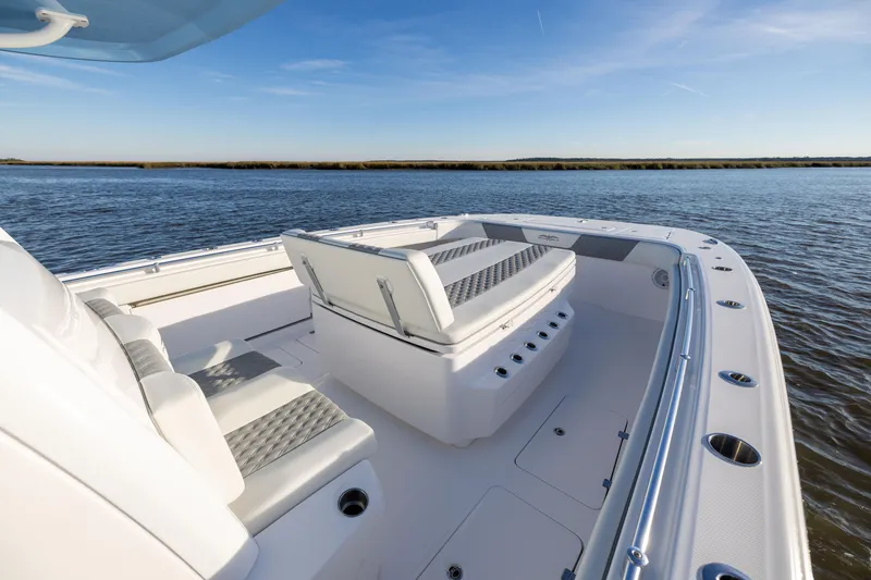 Slide: The Image of 2024 Invincible 40 Catamaran, spacious deck with seating, cruising on calm waters. - 50