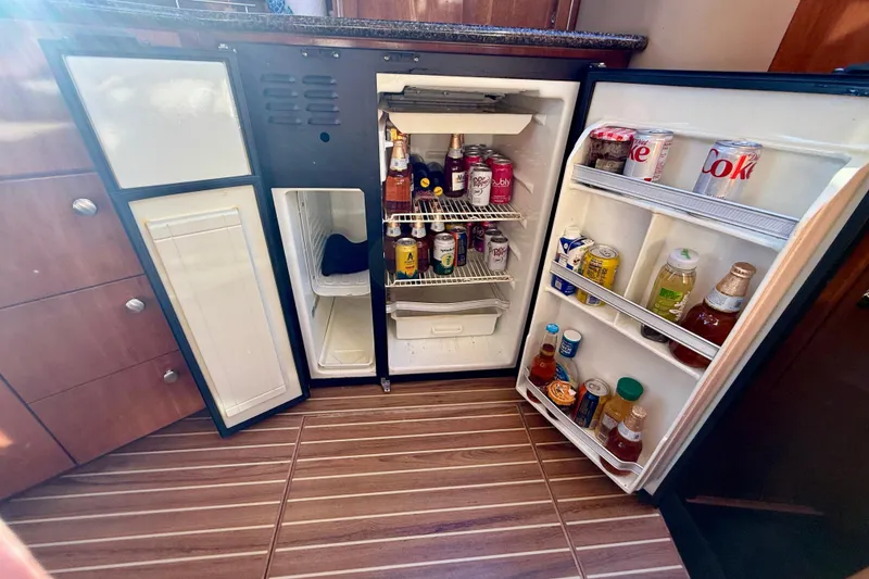 Slide: The Image of Open fridge in 2006 Meridian 391 Sedan yacht, stocked with beverages and snacks. - 19