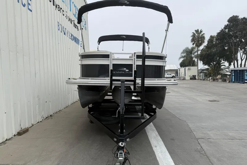 Slide: The Image of 2020 Bennington 22 SSRFBXP pontoon boat on trailer, parked near a building. - 5
