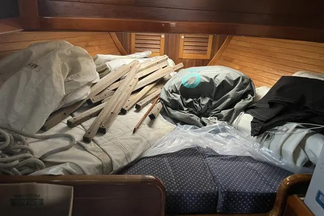 Slide: The Image of Interior of 1977 Alajuela A38 sailboat with ropes, wooden planks, and cushions. - 13