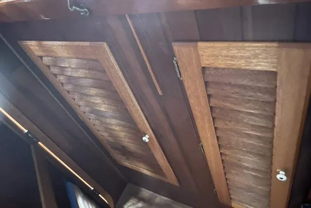 Slide: The Image of Wooden interior of 1977 Alajuela A38 sailboat, featuring louvered cabinet doors. - 14