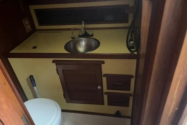 Slide: The Image of 1977 Alajuela A38 boat bathroom with sink, toilet, and wooden cabinetry. - 15