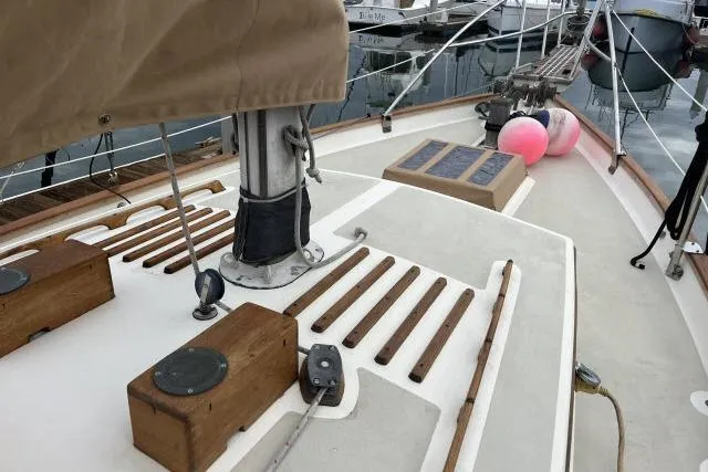 Slide: The Image of Deck of 1977 Alajuela A38 sailboat with wooden accents and docked surroundings. - 23