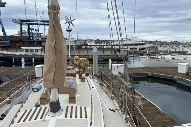 Slide: The Image of Sailboat Alajuela A38, 1977 model, docked at a marina with overcast skies. - 24
