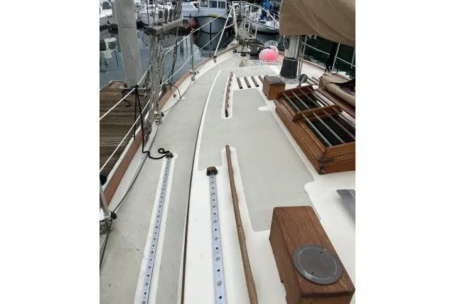 Slide: The Image of 1977 Alajuela A38 sailboat deck with wooden accents and marina background. - 28