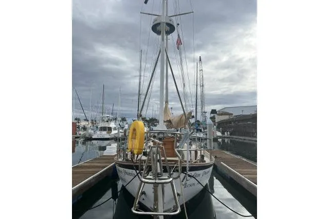 Slide: The Image of 1977 Alajuela A38 sailboat docked at marina under cloudy sky. - 34