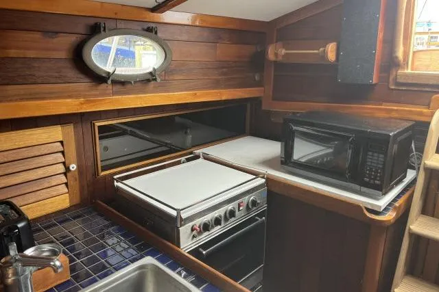 Slide: The Image of 1977 Alajuela A38 yacht kitchen with stove, microwave, and wooden interior. - 6