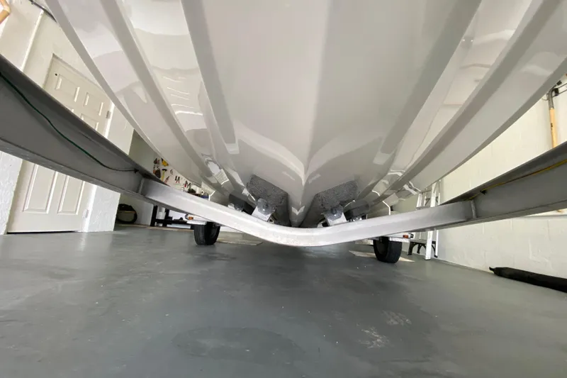 Slide: The Image of Underside view of a 2008 Famous Craft 18 boat on a trailer in a garage. - 10