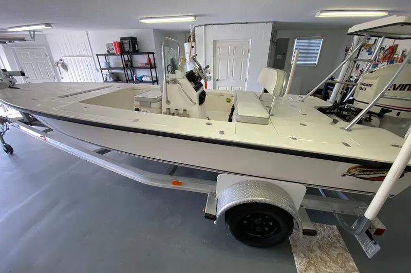 Slide: The Image of 2008 Famous Craft 18 boat in garage, on trailer, with Evinrude motor. - 11