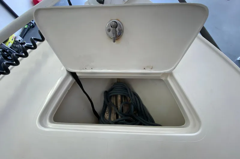 Slide: The Image of Open storage compartment on 2008 Famous Craft 18 boat, containing coiled rope. - 21