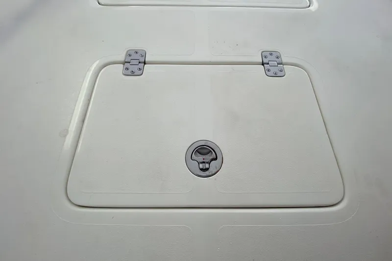 Slide: The Image of Hatch cover on a 2008 Famous Craft 18 boat, featuring metal hinges and latch. - 23