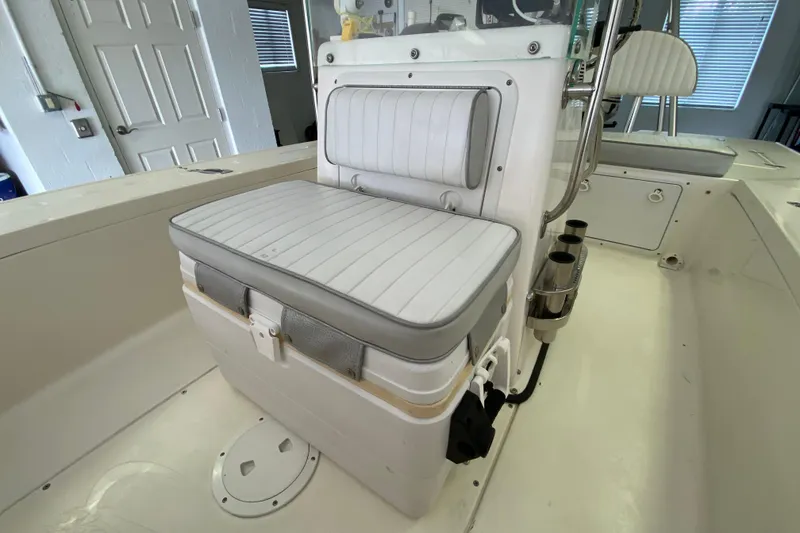 Slide: The Image of White cushioned seat on 2008 Famous Craft 18 boat, featuring rod holders and storage. - 31