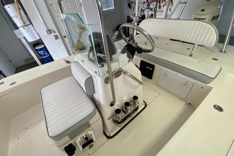 Slide: The Image of Interior of a 2008 Famous Craft 18 boat with white seating and steering console. - 38