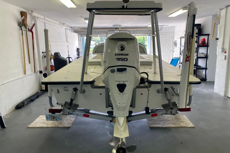 Slide: The Image of 2008 Famous Craft 18 boat with Evinrude 150 engine in a garage setting. - 4