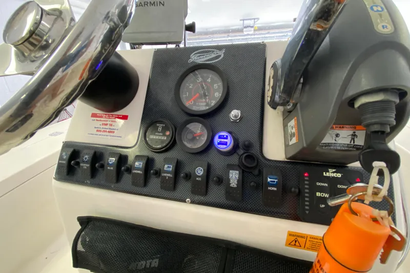 Slide: The Image of Control panel of a 2008 Famous Craft 18 boat with steering wheel and gauges. - 40