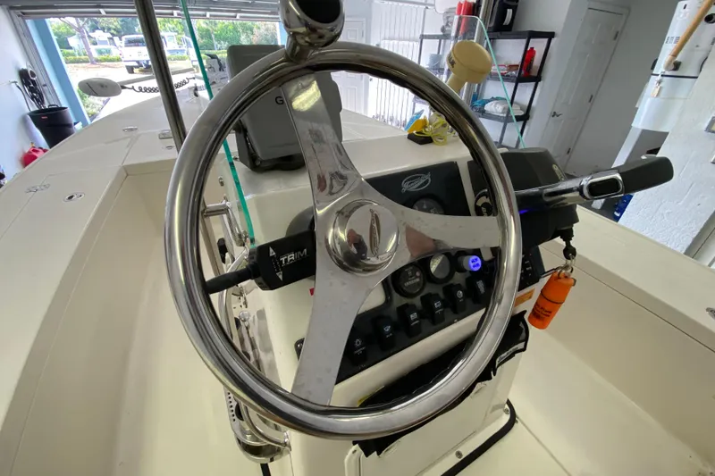 Slide: The Image of Steering wheel of a 2008 Famous Craft 18 boat, featuring control panel and throttle. - 44