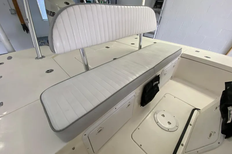 Slide: The Image of 2008 Famous Craft 18 boat interior with white cushioned seating and storage compartments. - 51