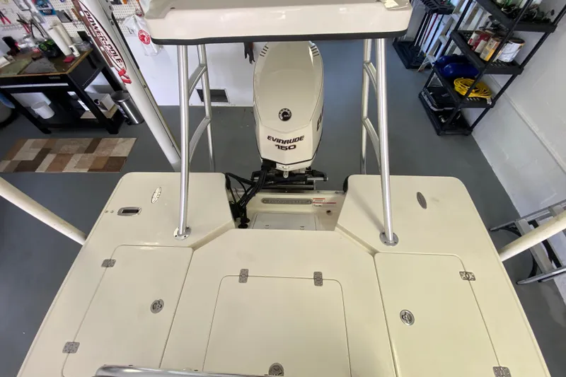 Slide: The Image of 2008 Famous Craft 18 boat with Evinrude 150 engine in a garage setting. - 54