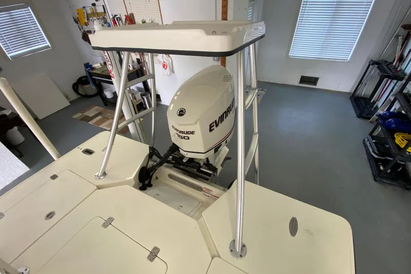 Slide: The Image of 2008 Famous Craft 18 boat with Evinrude 150 engine in a garage setting. - 64