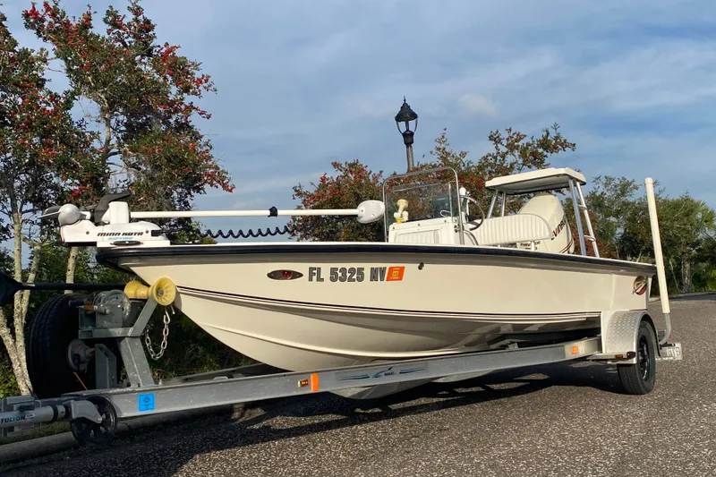 Slide: The Image of 2008 Famous Craft 18 boat on trailer, parked outdoors with trees in background. - 71