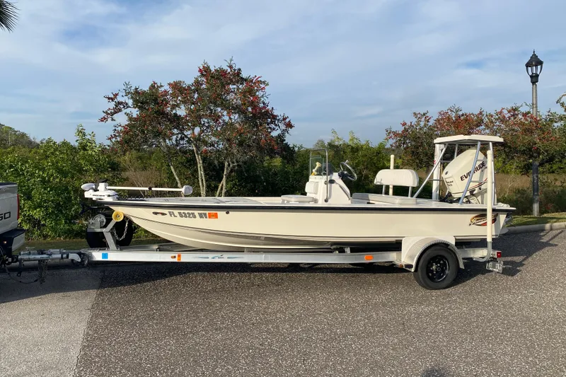 Slide: The Image of 2008 Famous Craft 18 boat on trailer, parked outdoors with trees in background. - 72