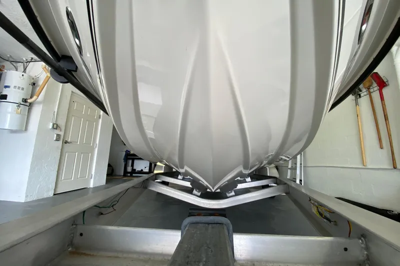 Slide: The Image of Underneath view of a 2008 Famous Craft 18 boat on a trailer in a garage. - 9