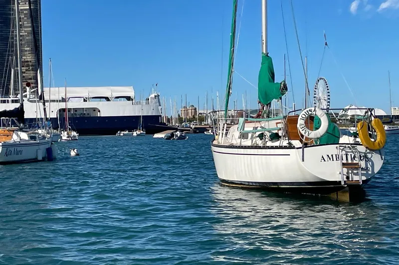 Slide: The Image of 1978 Hunter 30 sailboat anchored in a marina with clear blue skies. - 1