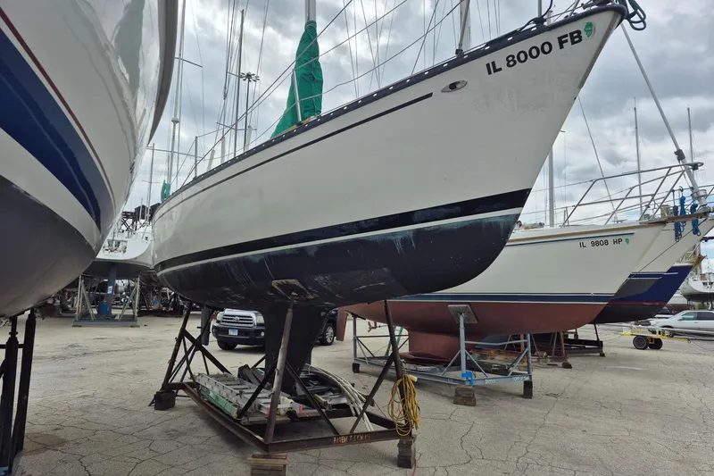 Slide: The Image of 1978 Hunter 30 sailboat on stands in a marina, overcast sky. - 15