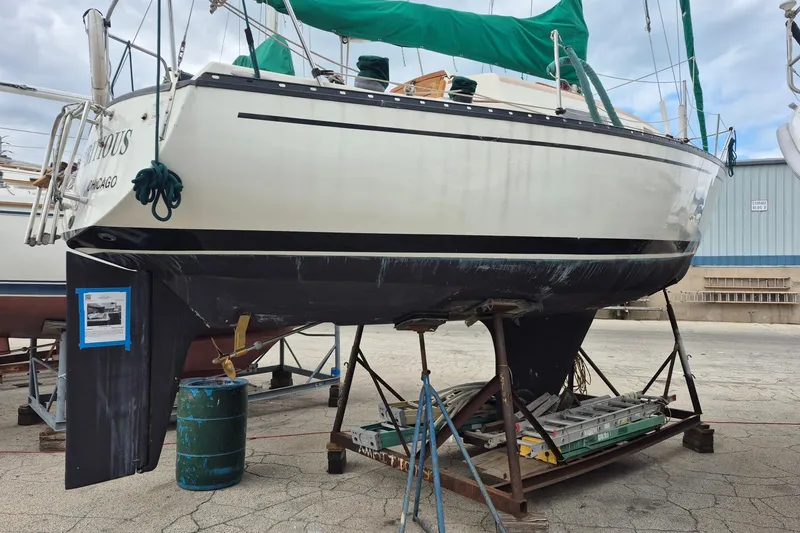 Slide: The Image of 1978 Hunter 30 sailboat on stands in a boatyard, overcast sky. - 16