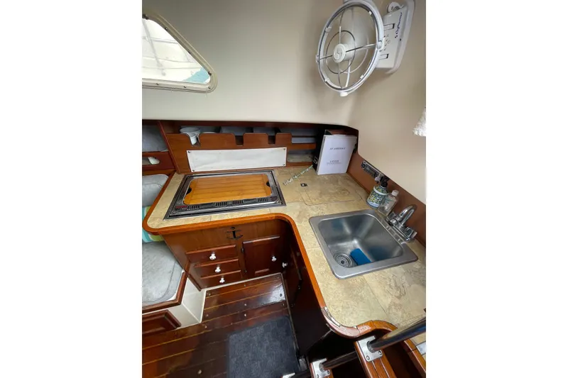 Slide: The Image of 1978 Hunter 30 yacht kitchen with sink, stove, and wooden cabinetry. - 19