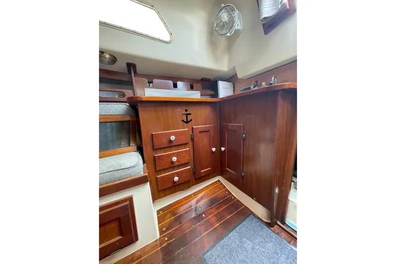 Slide: The Image of Interior of a 1978 Hunter 30 sailboat with wooden cabinetry and nautical decor. - 21