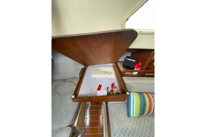 Slide: The Image of Interior of a 1978 Hunter 30 sailboat with open storage compartment and colorful pillow. - 22