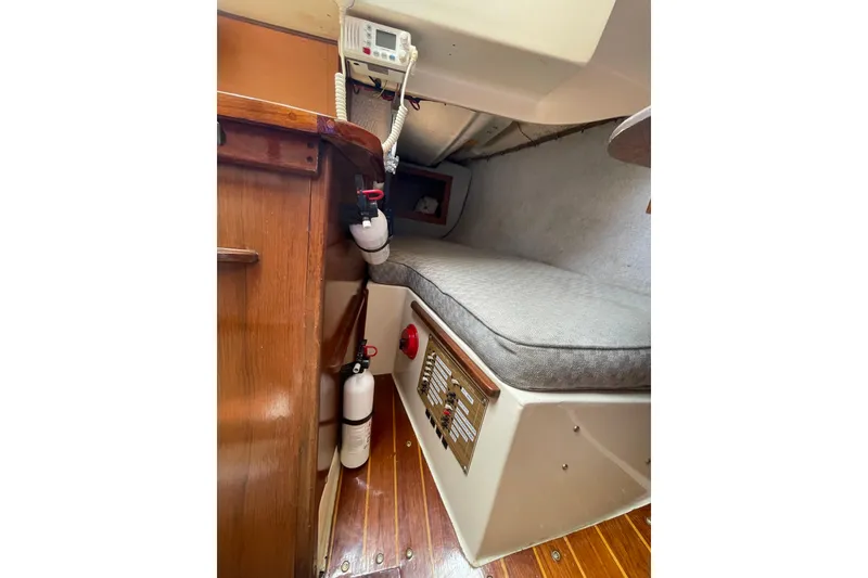 Slide: The Image of 1978 Hunter 30 sailboat interior with cushioned berth and wooden accents. - 23