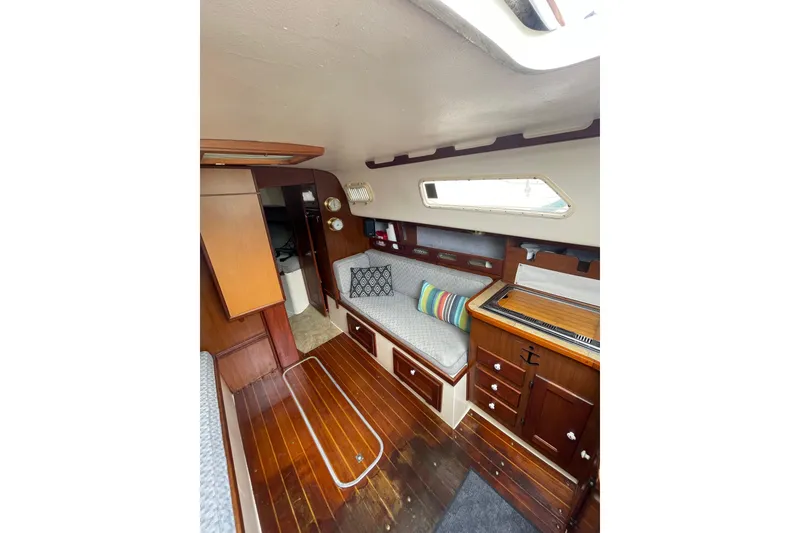 Slide: The Image of Interior of a 1978 Hunter 30 sailboat with wooden finishes and cozy seating. - 32