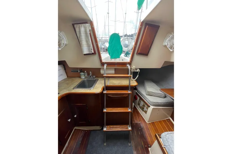 Slide: The Image of Interior of a 1978 Hunter 30 sailboat with wooden steps and compact kitchen area. - 33