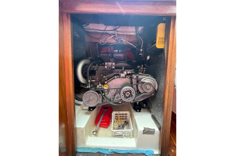 Slide: The Image of Engine compartment of a 1978 Hunter 30 sailboat, showcasing mechanical components and tools. - 36