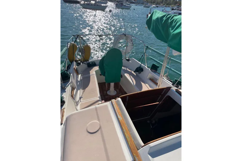 Slide: The Image of 1978 Hunter 30 sailboat with green covers, docked in a sunny marina. - 5